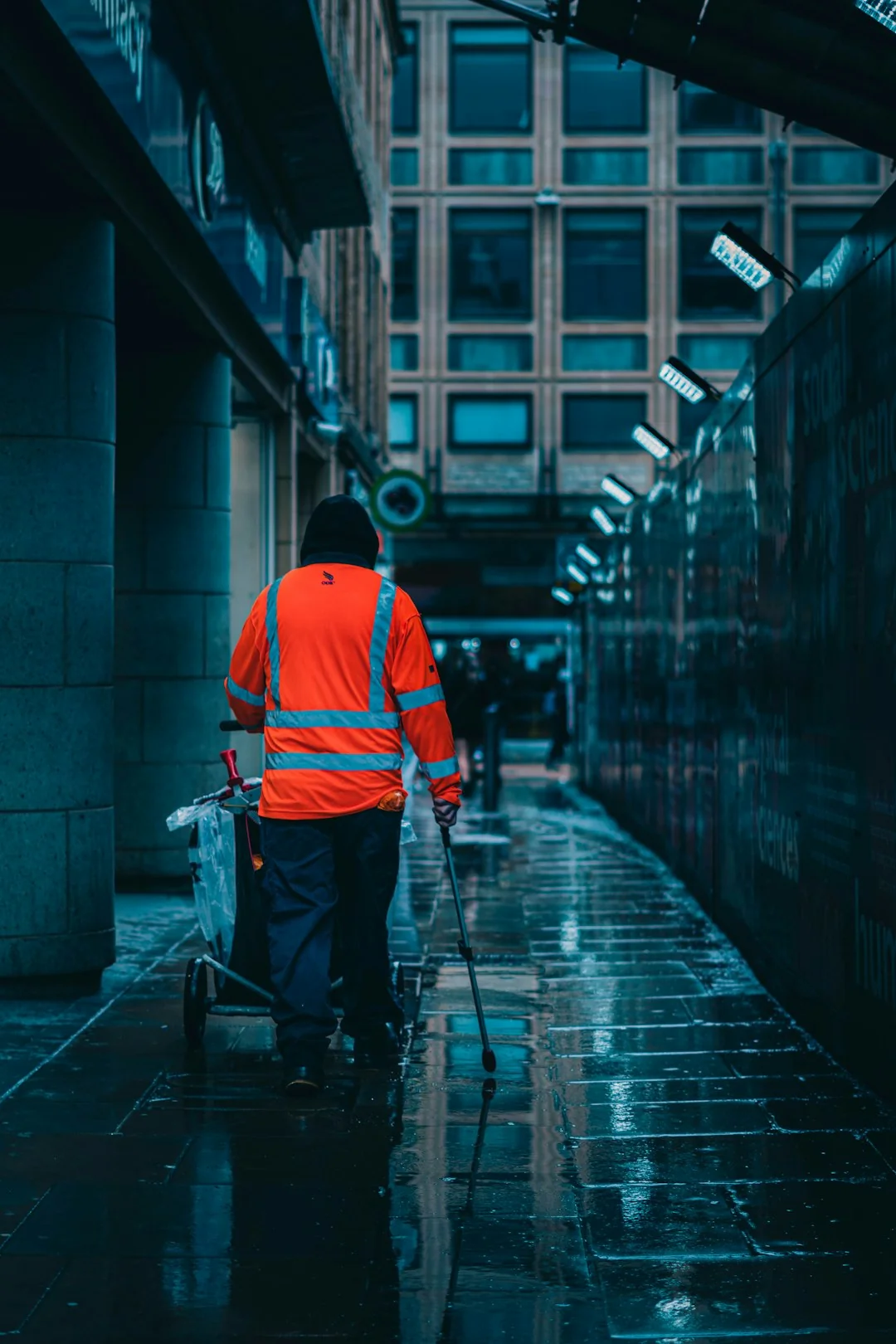 A man washing skyscraper windows while secured in a harness, highlighting urban high-rise work.